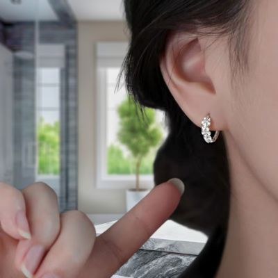 boucles d'oreilles fleurs montrées  du  doigt