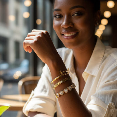 bracelets manchette couleur or femme souriante coude sur la table