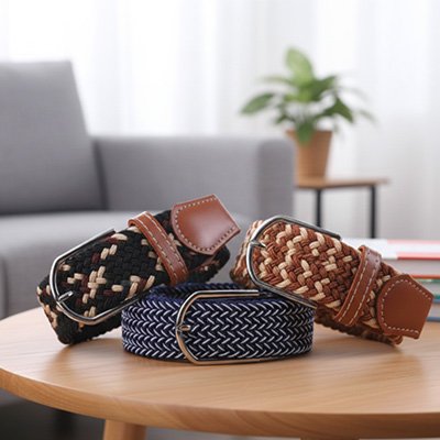 Ceinture tressée femme​ les trois couleurs enroulées sur une table