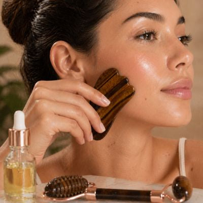 femme utilisant le gua sha sur la joue effet lift