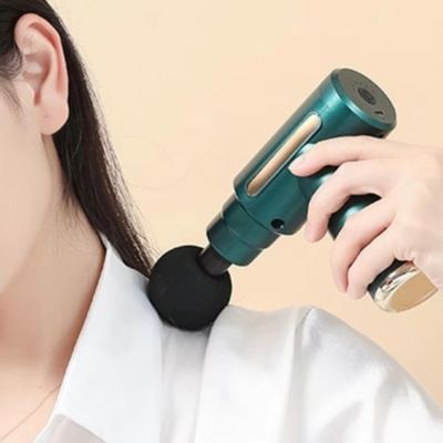 femme utilise mini pistolet de massage vert