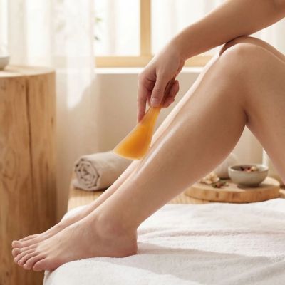 femme utilise spatule gua sha massage pieds