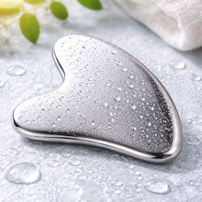 gua sha acier inoxydable sur surface humide